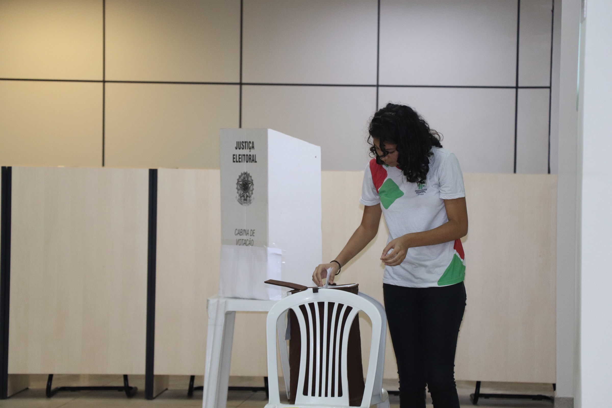 Estudante com uniforme do Ifap no momento que coloca a cédula de votação na urna. Foto: Suely Leitão (Deice/Ifap)